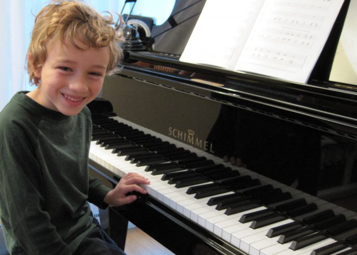 Young boy studying piano lessons