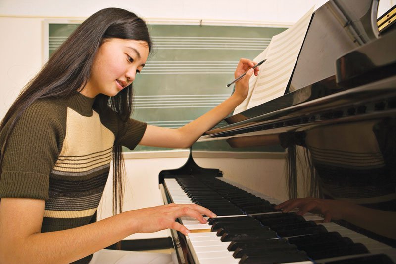Asian girl studying piano